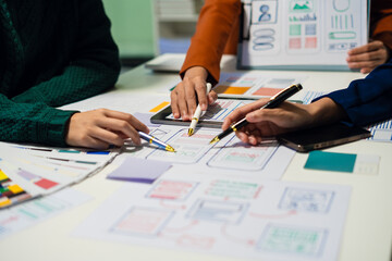 ui designer brainstorming about mobile app interface wireframe design with customer breif and color code at office.