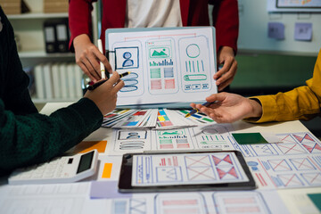 ui designer brainstorming about mobile app interface wireframe design with customer breif and color code at office.