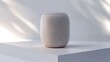 © Galib - A white smart speaker on a white platform with natural light.