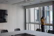 © ReeldealHD images - Businesswoman on a phone call in an empty office conference room looking out of the window