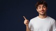 © Galib - A young man with a beard smiles at the camera and points with his index finger.