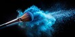 © Indigo Studio - Cosmetic brush creating a vibrant blue powder explosion on a black background