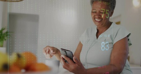 Sticker - Animation of cardiograph over senior biracial woman using smartphone at home