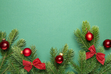 Poster - Fir tree branches with Christmas decor on green background, flat lay. Space for text