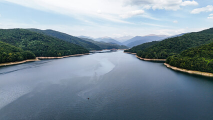 Wall Mural - Carpathian mountains with Vidraru dam and lake. Top cinematic aerial view. Romania, Transfagaras road. The most famous and beautiful road in the Europe