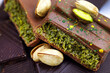 © KatMoy - Dubai Chocolate bar with green kadayif and pistachio spread with pistachio nuts close up