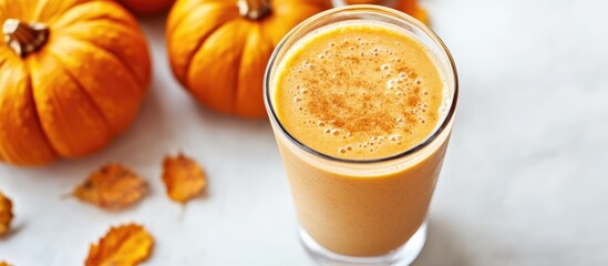 Poster - Close up of a healthy pumpkin spice smoothie alongside pumpkins on a white background. with copy space image. Place for adding text or design