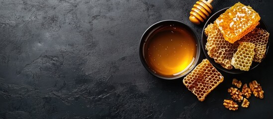 Poster - Fresh honey for dessert Bowl of honey honeycomb and nuts on a black table top view copyspace