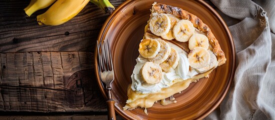 Leinwandbilder - Plate with a slice of delicious banana pie on a wooden surface. with copy space image. Place for adding text or design