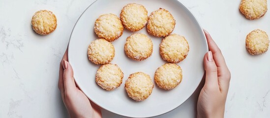 Aufkleber - Coconut biscuits on a white plate held in someone s hand top view flat lay. with copy space image. Place for adding text or design