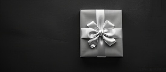 Poster - Black and white a sophisticated and meticulously arranged gift box against a black backdrop New Year and Christmas theme Valentine s gift idea Top view Space for text Copyspace Negative space Templat