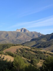 Canvas Print - A distant mountain range with a blue sky and rolling hills.