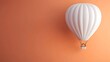© Malik - Minimalist white hot air balloon on a pastel orange background, offering open space for a clean and modern travel concept.