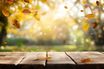 Wall Mural - wooden table with an autumn background and blurred golden-yellow bokeh light, with falling leaves in