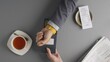 © kinomaster - Top view of man hand paying bill at cafe or restaurant with smart watch using portable terminal.