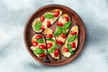 Wall Mural - Italian mini pizza . Aubergine (eggplant ) with mozzarella cheese and basil . On rustic background