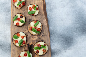 Wall Mural - Italian mini pizza . Aubergine (eggplant ) with mozzarella cheese and basil . On rustic background