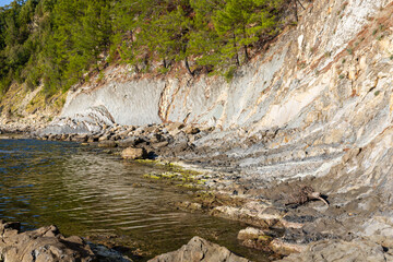 Wall Mural - A scenic view of the ocean meeting a rocky coastline, perfect for travel or nature-themed projects