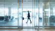 © Ali - businessman walking through glass door in modern office