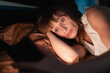 © Andrii Lysenko - Sleepy woman awake at night using smart phone lying in bed in her bedroom. Using mobile for chatting