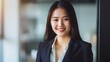 © Evalva786 - Young Asian Businesswoman in Suit, Smiling, Business Theme, Professional, Portrait Shot, Plain Office Background