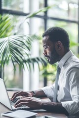 Wall Mural - A person sitting at a desk using a laptop computer, great for office or home use