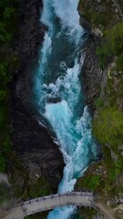 Wall Mural - Aerial vertical footage of the flowing Tora River and Tora utleggsbru bridge in Billingen, Norway