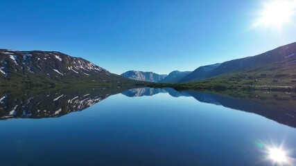 Wall Mural - Drone tranquil view of Otta river on a sunny day surrounded by mountains with reflection in water