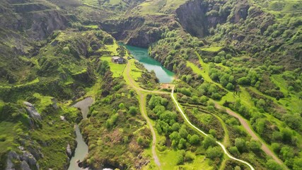 Wall Mural - Drone view over a green Lake in La Arboleda surrounded by lush green hills on a sunny day