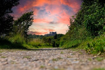 Poster - Castle view with dirt path and sunset sky