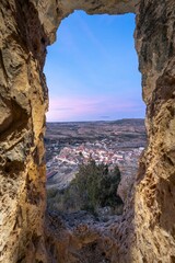 Wall Mural - Scenic town view through rock window at sunset