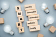 © patpitchaya - SMART acronym on wood blocks with glowing light bulbs, smart goal setting concept