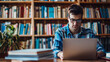© Kanlayarawit - A university student wearing a glasses is learning online in a library with bookshelves in the background.