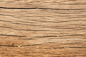 Close-up of a weathered wooden surface with visible grain and cracks.