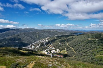 Wall Mural - View of a Alpine village set in Falls Creek valley NSW, Australia surrounded by lush green hills.