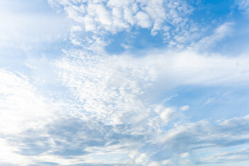 Fluffy white clouds drift across a clear blue sky, painting a breathtaking summer day