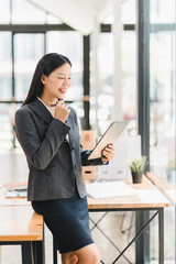 Wall Mural - Professional woman smiling while using tablet in modern office