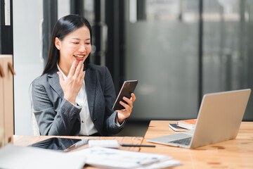 Wall Mural - A professional woman smiles while using her smartphone in modern office setting