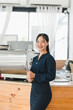 © PRIME STOCK LAB - A smiling woman in dark outfit stands confidently in modern cafe
