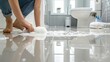 © kornc - A person is cleaning a bathroom floor with a sponge