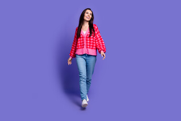 Poster - Full length photo of charming positive woman wear pink cardigan walking empty space isolated purple color background