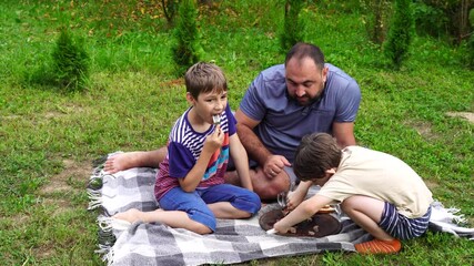 Wall Mural - Father and sons have picnic on the backyard, have fun and time together