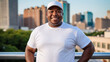 © QuoDesign - Plus size black man wearing white t-shirt and white baseball cap standing on cityscape background