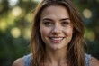 © Kasuni - A smiling young woman with long hair stands against a soft, blurred green background, radiating warmth and positivity in a natural setting.