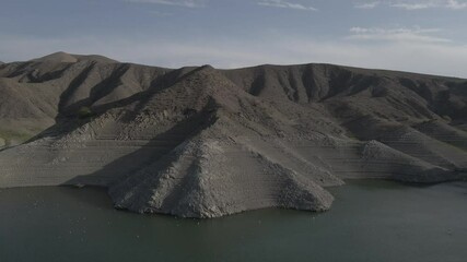 Sticker - birds flying over lake near rugged cliff, against clear sky in Azat Reservoir, Armenia