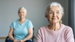 © pornchan - Older woman doing chair exercises with a wellness instructor in a senior center, elderly chair exercise program, mobility wellness