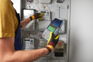 Wall Mural - Technician reading consumption and charging on a wireless electricity power meter station in a building.	
