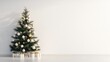 © Pannin - A minimalist Christmas tree decorated with gold and white ornaments, with a blank wall to the side for inserting holiday greetings.