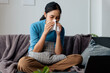 © aksonsat - Woman is ill sick with fever, a runny nose and cough feeling under weather under blanket in the living room at home and wipe a nose with facial tissue.