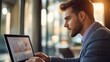 © Plaifah - Close-up of a young businessman in a sharp suit, confidently looking at a laptop screen with financial charts, showcasing professionalism and focus.